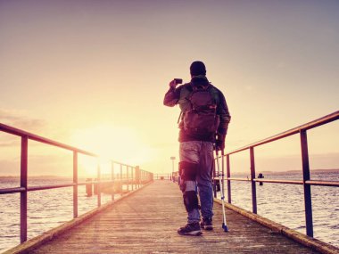 Adam sadece fotoğraf makinesi telefon ile anılar elinde tutuyor. 