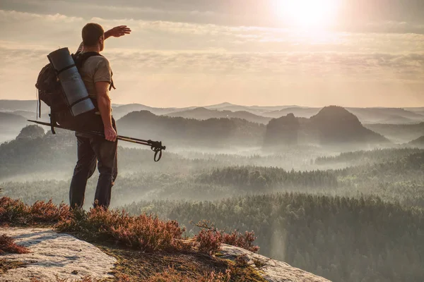 Turista con mochila a pie sobre rocas de montaña —  Fotos de Stock