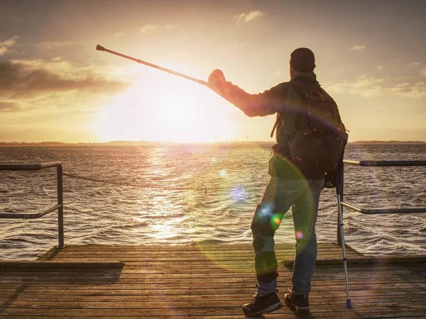 Touristen beobachten Sonnenaufgang draußen an der Strandbrücke — Stockfoto