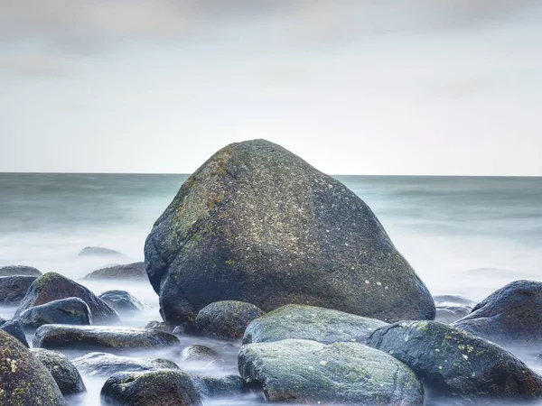 Costa del mar, océano. Piedras en la costa. Agua azul — Foto de Stock