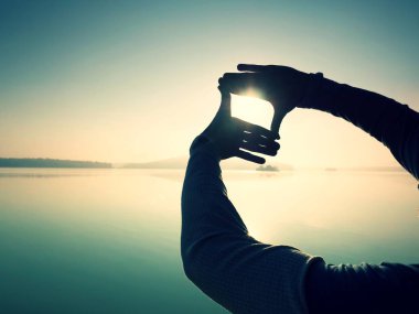 Plajda güneş ışığı ile el tarafından yapılmış olan şekil silüeti. 