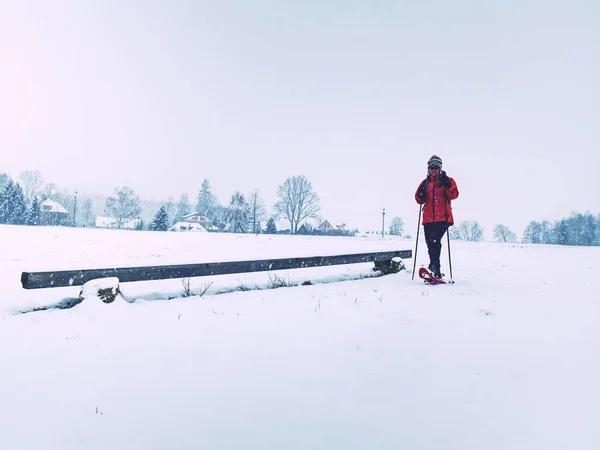 Sonrisa cara deportes chica caminar en raquetas de nieve en nevado prado — Foto de Stock
