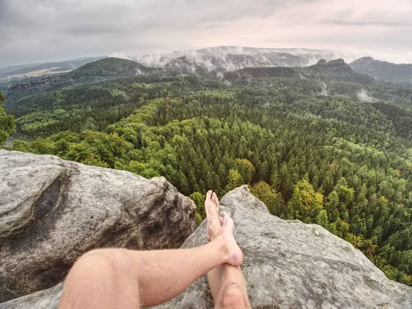 Man taking a break in nature and looking from summit down