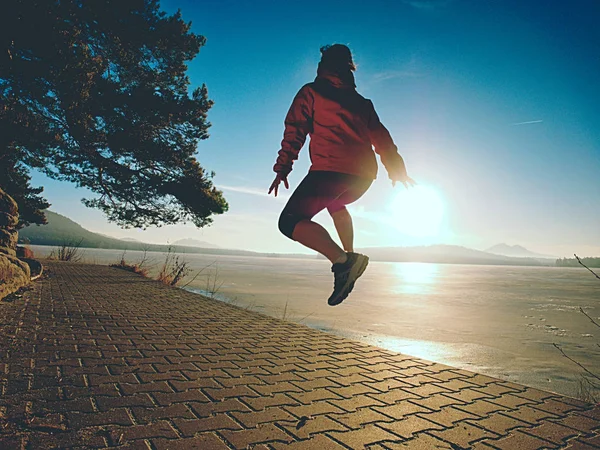 Athletic fitness woman jumping and running on beach at sunset. — Stock Photo, Image