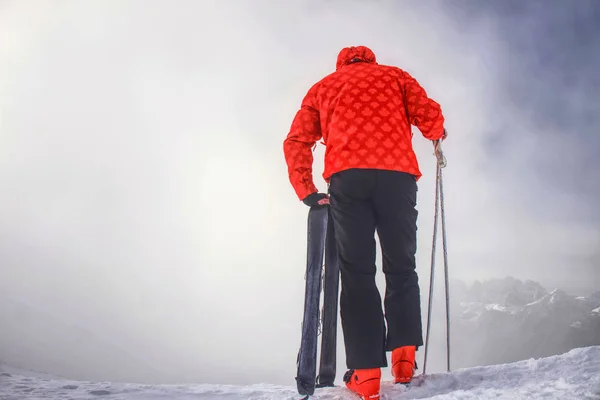 Skifahrer übernachten mit Skiern am Bergrand oberhalb des tiefen Hangtals — Stockfoto
