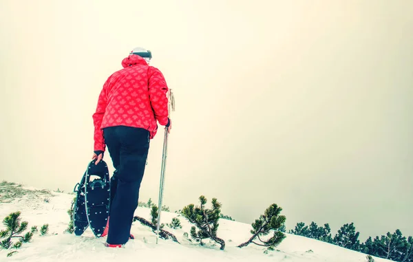 Hombre con raquetas de nieve en el camino de la nieve. Hombre en raquetas de nieve —  Fotos de Stock