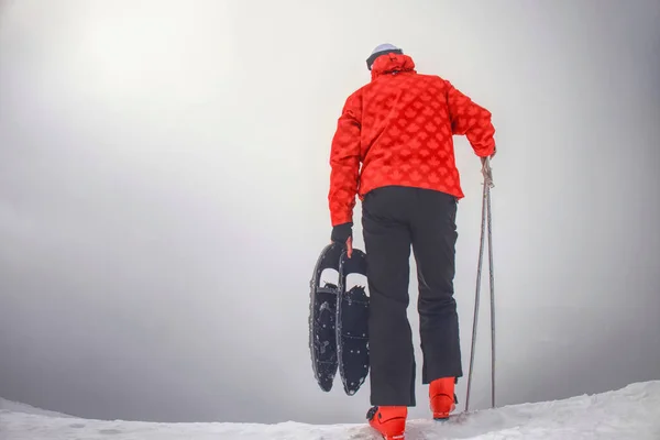 Man met sneeuwschoentrails op de sneeuw weg. Man in sneeuwschoenen — Stockfoto