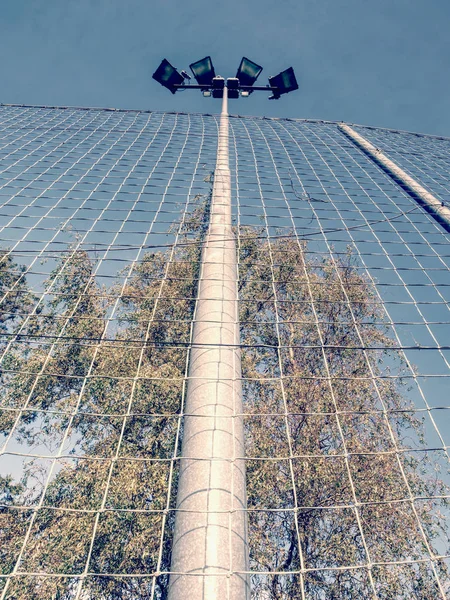 Torre holofote com céu azul. A torre de luz do estádio — Fotografia de Stock