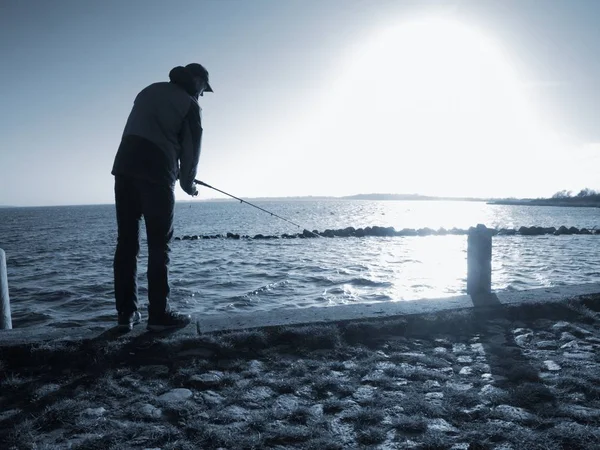Pescador con sombrero en el topo de mar con caña de pescado . —  Fotos de Stock