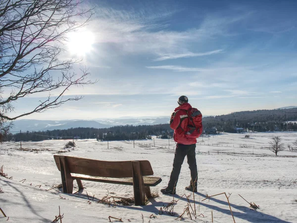 Man tourist at bench in winter landscape — Stock Photo, Image