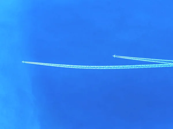 Cielo con piste di fumo bianco di aereo volante . — Foto Stock