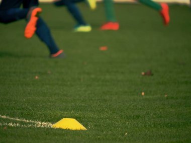 Sarı eğitim konisi. Çocuk parkında futbol eğitim ekipmanları