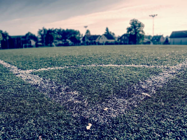 Striscia bianca sul campo di calcio verde artificiale. foglie gialle cadute — Foto Stock