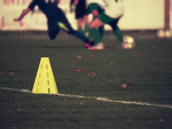 Sárga tölcsér egy füves focipályán. Műanyag futball zöld gyep — Stock Fotó