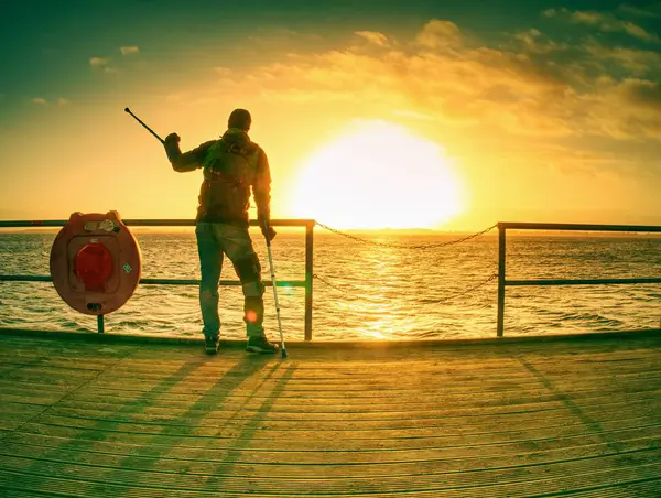 Silhueta de homem com mochila no cais no mar calmo — Fotografia de Stock