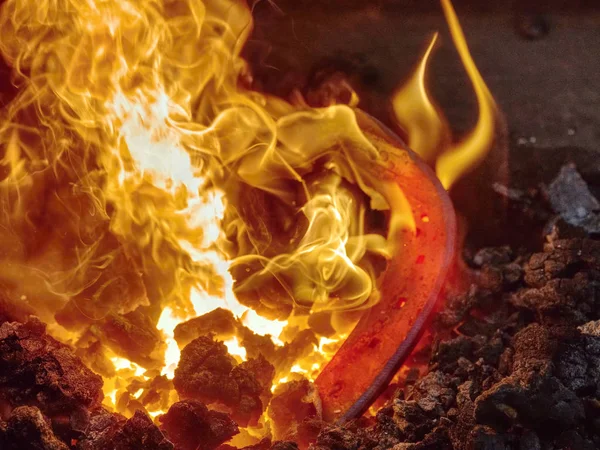 Iron bar heating in old blacksmith furnace — Stock Photo, Image