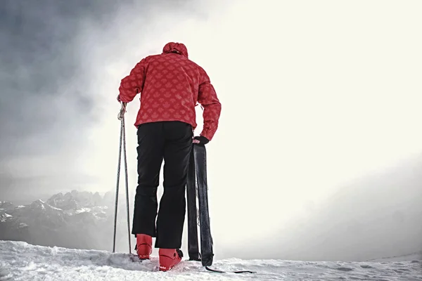 Człowiek na krawędzi zbocza, narciarz stojący na świeżym śniegu — Zdjęcie stockowe