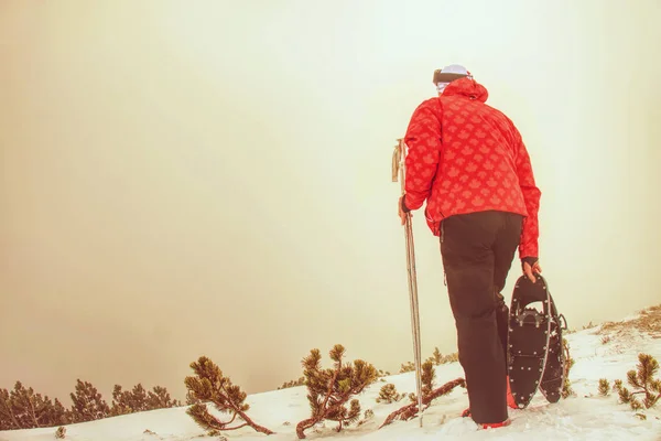 Człowiek z obuwiem śnieżnych w górach zimą. — Zdjęcie stockowe