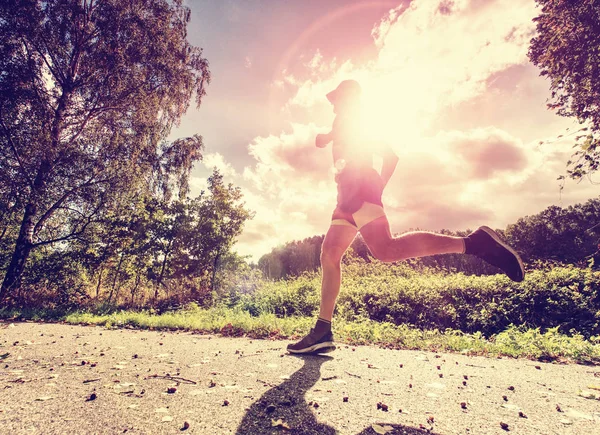 Hombre corriendo y haciendo ejercicio solo en el parque. El sol detrás — Foto de Stock