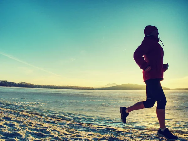 Bieganie lub jogging na plaży zimą, słoneczny dzień rano — Zdjęcie stockowe