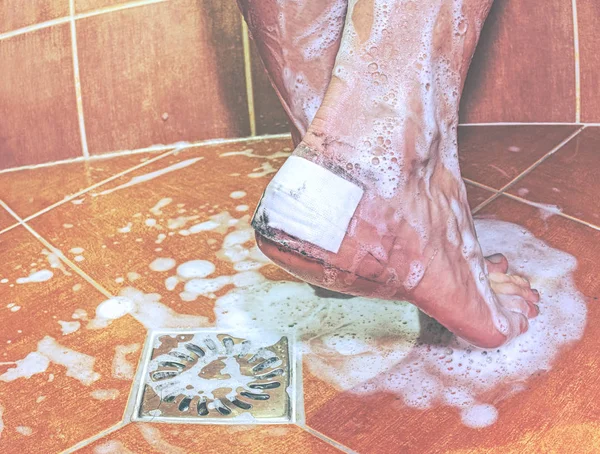 Plaster cover blister on heel in shower. — Stock Photo, Image