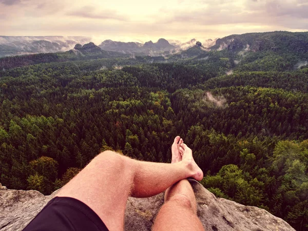 First person perspective shot from hiker sit at edge of cliff — Stock Photo, Image