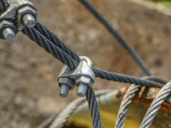 Shackles attached to wire cables and safety net.