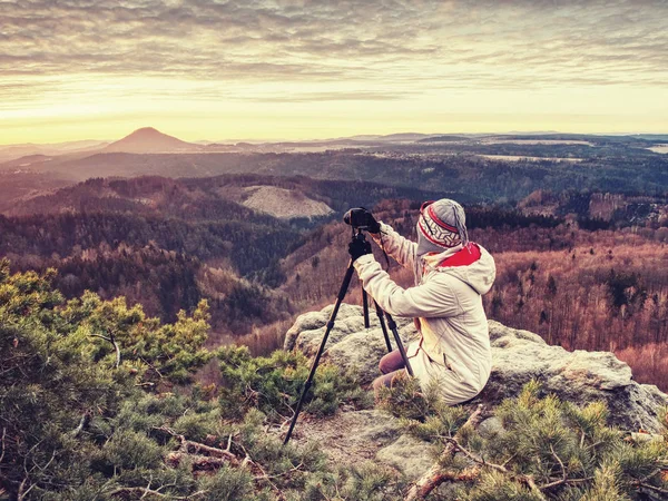 Milá žena v teplých šatech, fotografující svítání nad zemí — Stock fotografie