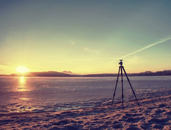Замерзшее озеро зимой. Пейзаж Зимнего озера с оранжевым солнцем — стоковое фото