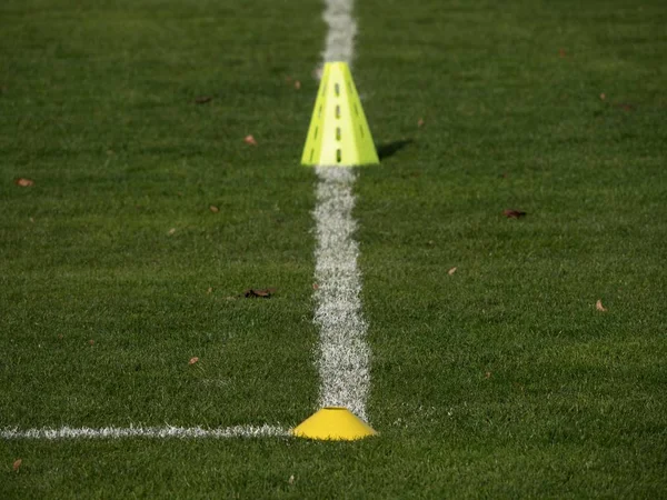 Yellow training cone. Soccer training equipment on playground