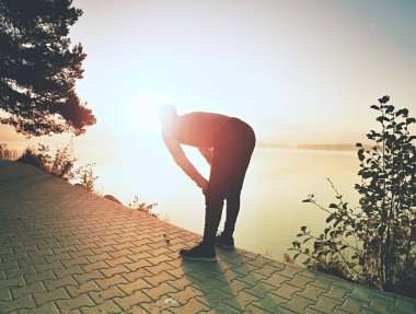 Kısa mola nefes için. Etkin adam göl plajda silüeti