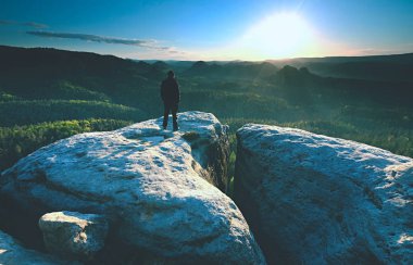Erkek silueti keskin zirvede kalır. Yürüyüşçü keyfini çıkarın görünümü.