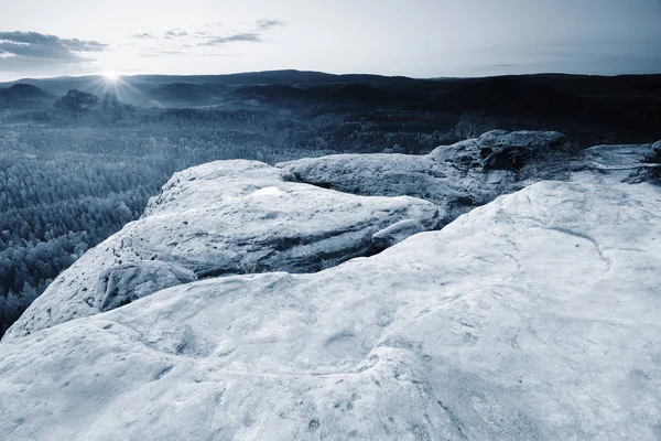 Picco roccioso sopra la nebbia inversa. Tempo freddo primaverile in montagna — Foto Stock