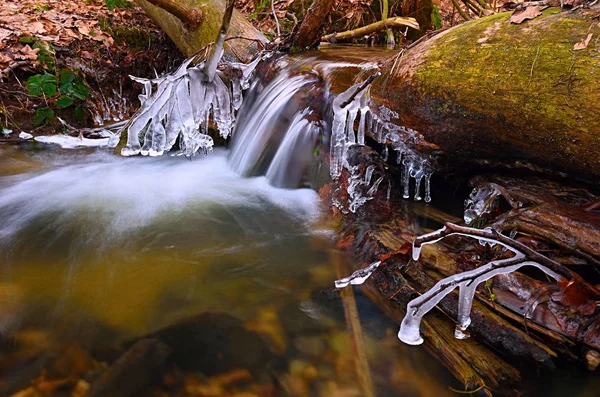 Bevroren cascade van waterval ijzige twijgen en rotsblokken in bevroren schuim — Stockfoto