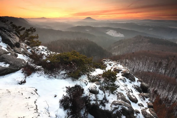 První sněhová pokrývka na pískovcové skále nad údolím. — Stock fotografie