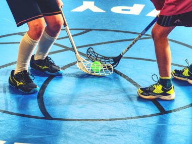 Player in the bully area. Man playing floor hockey on court. clipart
