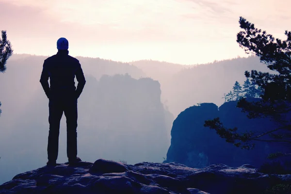 Самоуверенный турист в позе аккимбо на вершине скалы — стоковое фото