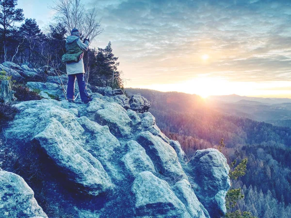 Milá žena v teplých šatech, fotografující svítání nad zemí — Stock fotografie