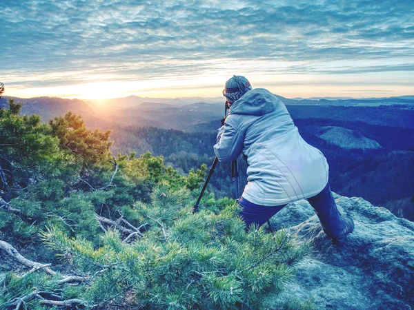 Vrouw wandelaar set statief met camera op blootgesteld rotsachtige top — Stockfoto