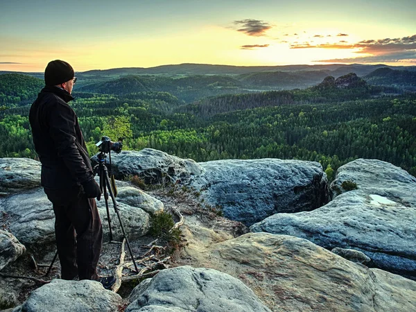 Photographer takes photos with camera on tripod on rock — Stock Photo, Image