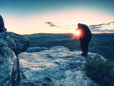 Uzun fotoğrafçı dağların fotoğrafını çekmek için kamera hazırlamak