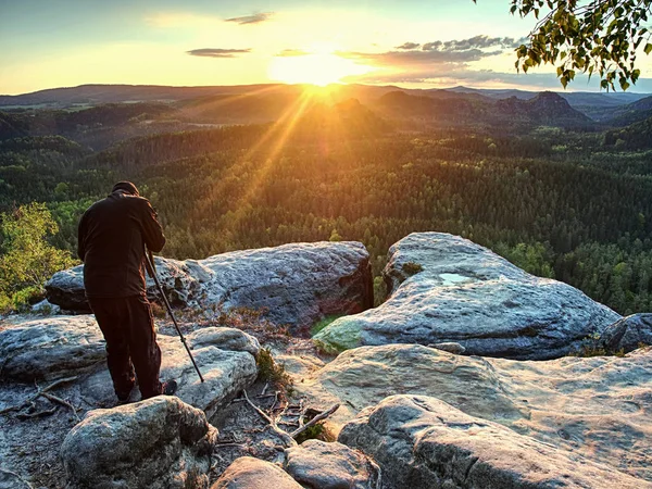 Fotógrafo alto prepara câmera para tirar fotos de montanhas — Fotografia de Stock