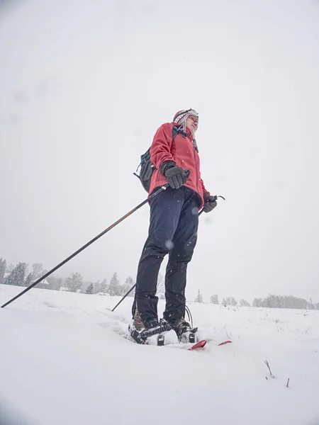 Χαμόγελο πρόσωπο σπορ κορίτσι με τα πόδια σε χιονοπέδιλα σε χιονισμένο λιβάδι — Φωτογραφία Αρχείου