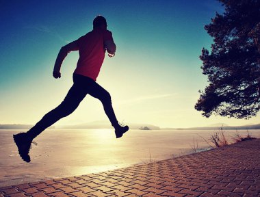 Atlet Runner kumda ayak izleri bırakarak plaj boyunca çalıştırmak
