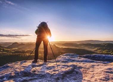  Sanatçı tripod üzerinde kamera tutarak ve görünüm bulucu ile işaret 