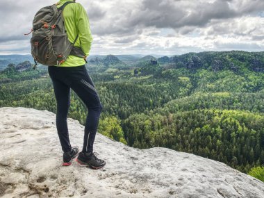 Bahar kayalık dağlar. Kaya üzerinde sırt çantası standı ile Hiker