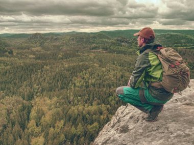 Bahar kayalık dağlar. Kaya üzerinde sırt çantası standı ile Hiker