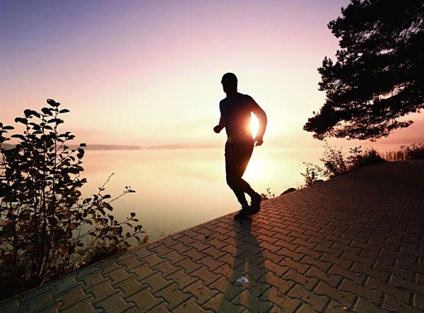 Silhouette eines Läufers am Strand bei Sonnenuntergang mit Sonne — Stockfoto