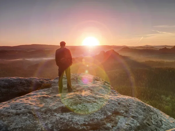 Hombre excursionista en la cima de la montaña. Bonito amanecer en el paisaje brumoso . — Foto de Stock