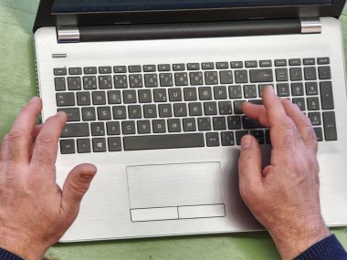 Dizüstü bilgisayar kullanarak e-posta yoluyla mesaj yazarak eski erkek serbest 